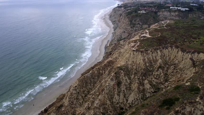 Aerial landscape of the rocky coastline at the edge of a beach