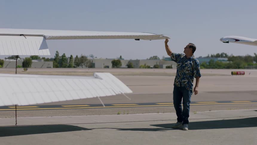 Man examines the wing of an airplane at a small airport
