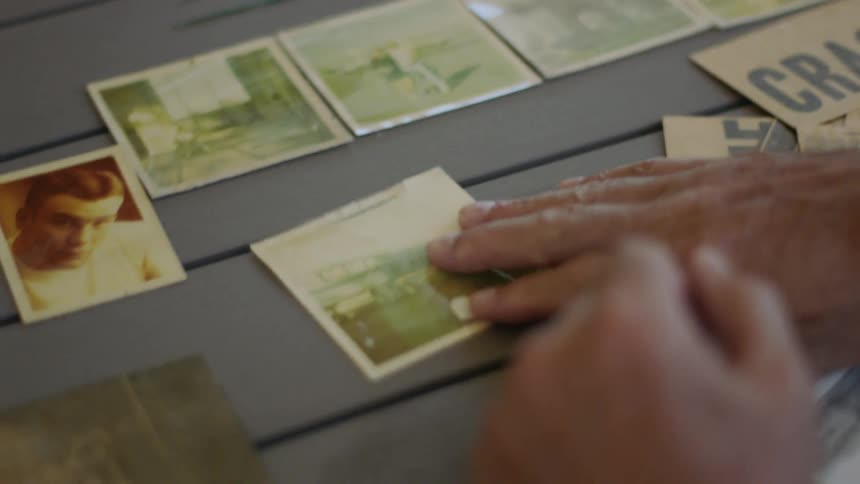 Man looking through old photographs and placing them on the table