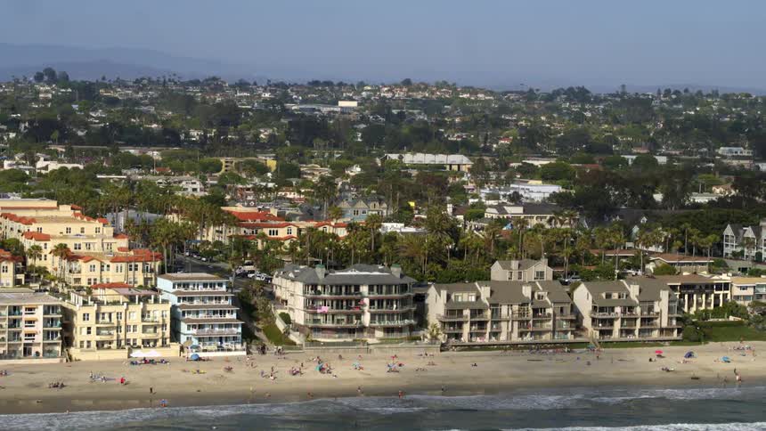 Several houses close to the sand of a beach facing the sea seen from above