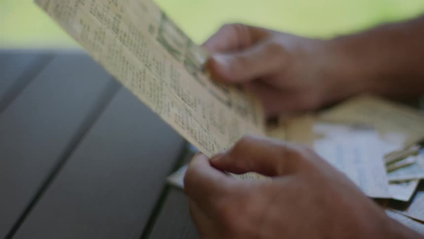 Pair of hands holding a brochure on a wooden table