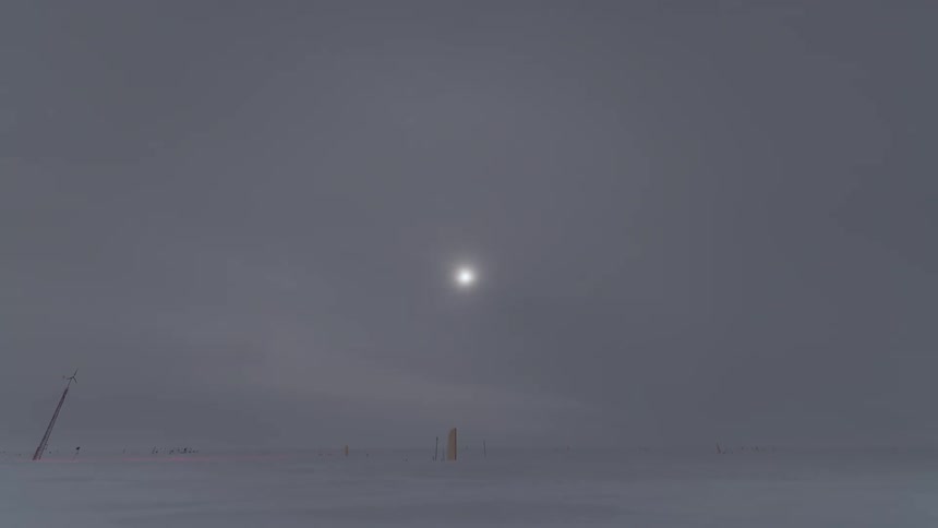 The sun shines feebly through a snow storm on a plain
