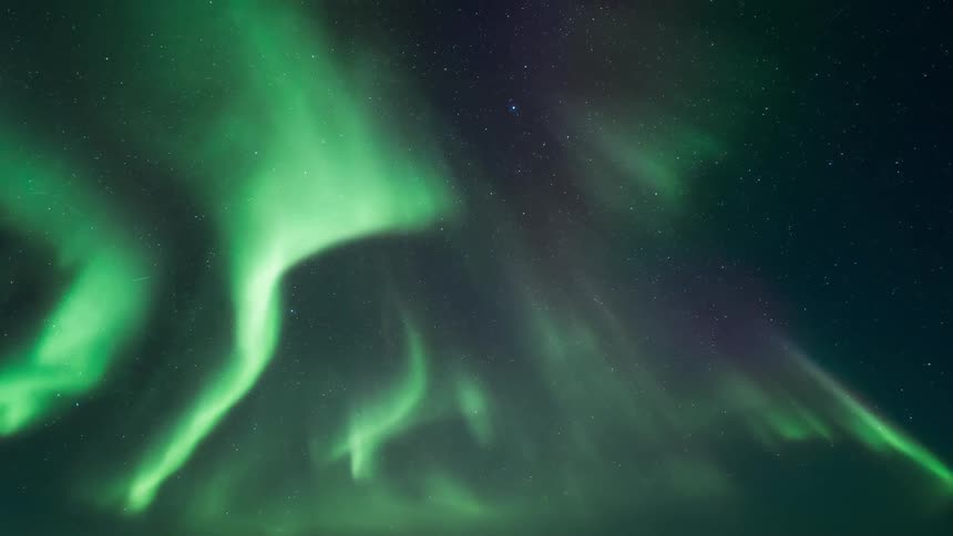 A green aurora flickers and shimmies in a night sky