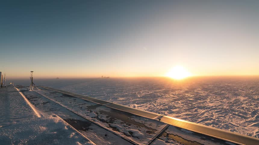 Ship flying over a snowcovered ground with the sun on the horizon