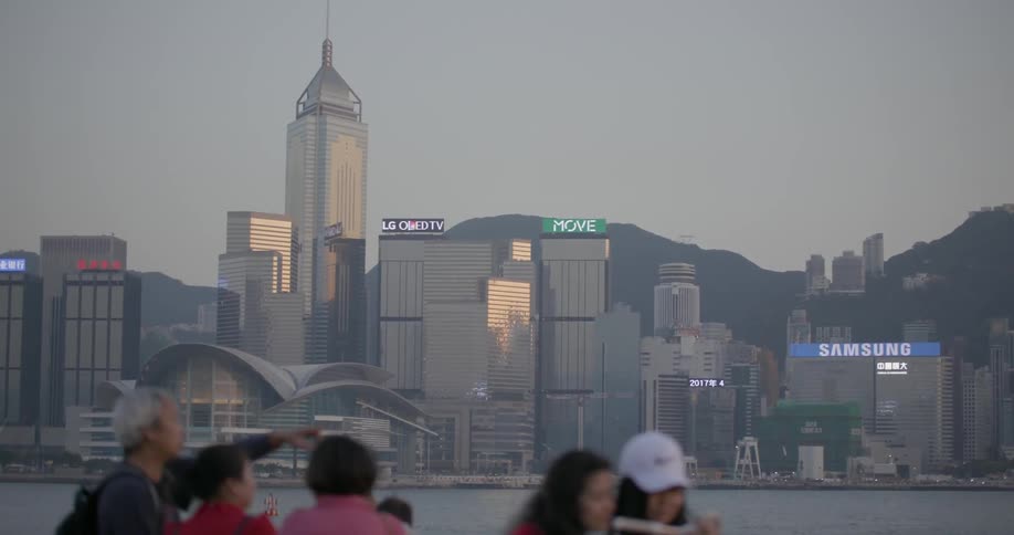 People looking across a river towards a large city