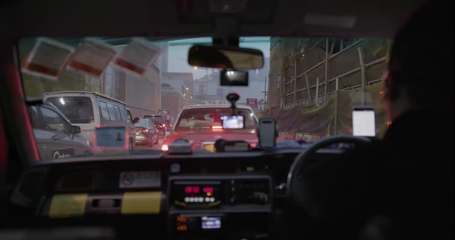 A person driving slowly in heavy traffic through downtown