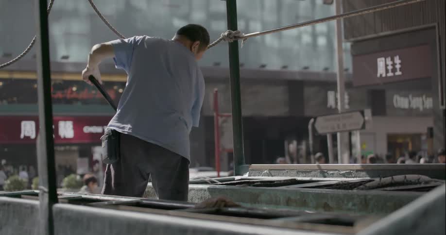 A man removes fresh fish from a barrel in Hong Kong