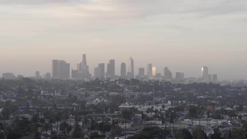 Los angeles sits in the haze beyond suburbs and palm trees