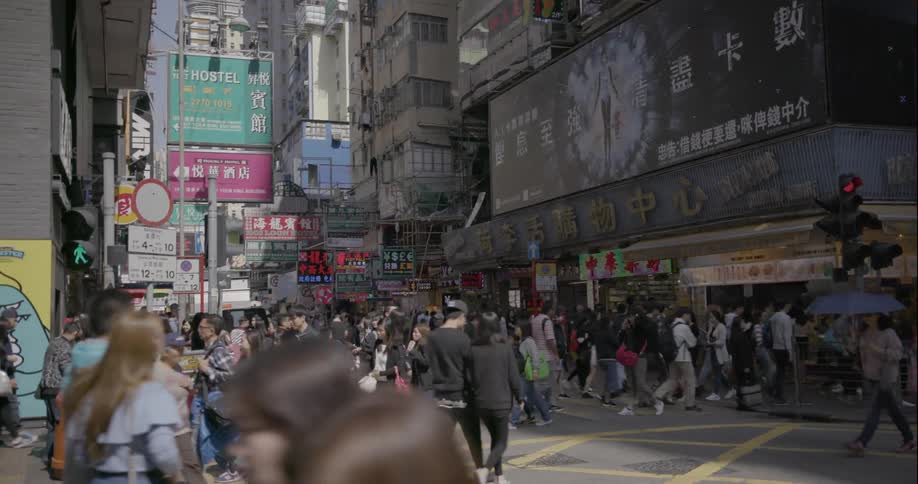 Pedestrians walk through crosswalks in a busy asian urban center