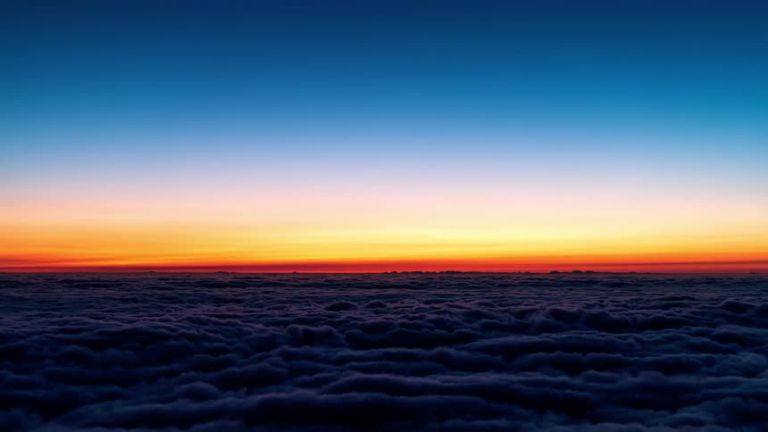 The sun sets over a vast number of roiling clouds