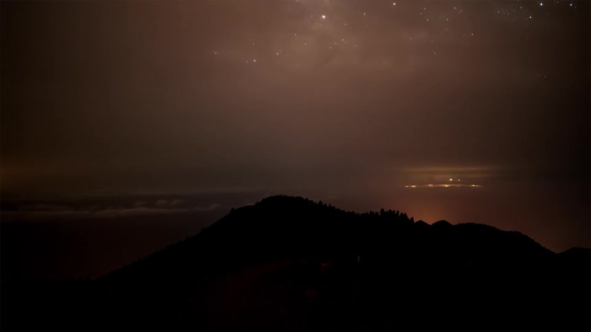 Silhouette of mountains against a sky with stars