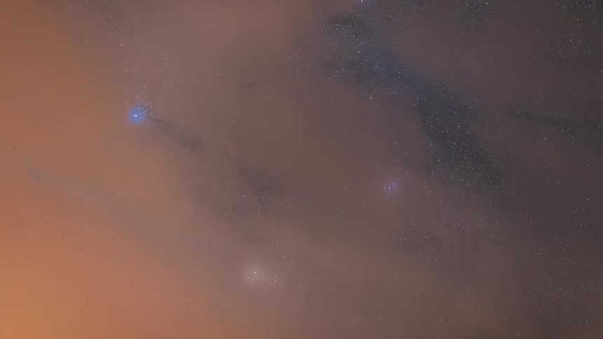 Time lapse of clouds rolling under a clear starry sky