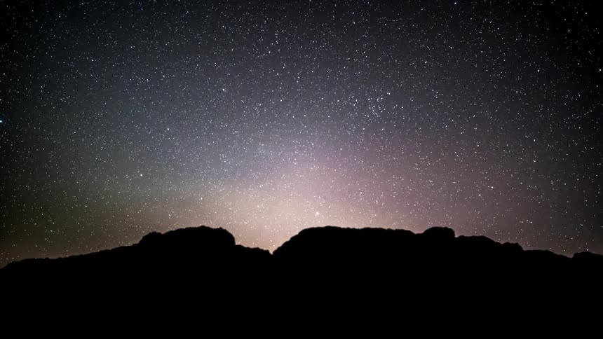 Time lapse of a starry sky over the silhouette of a mountain range