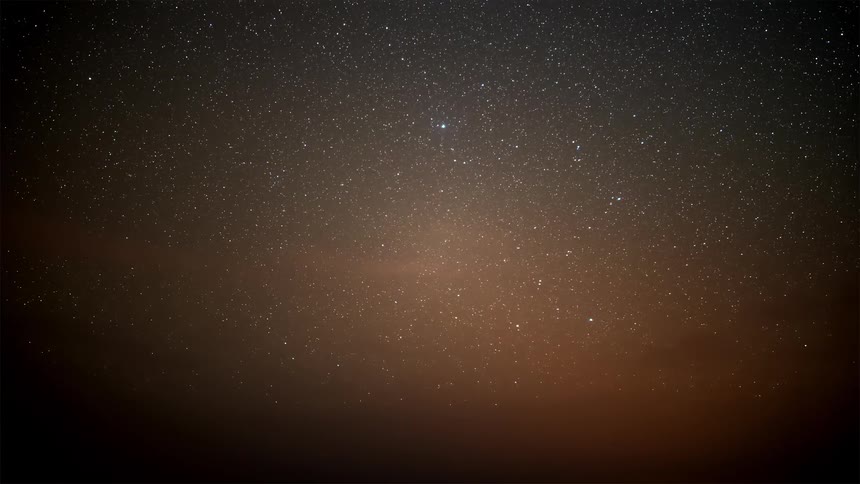 Silhouette of mountains against a night sky with stars