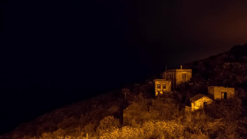 Time lapse of a night scene with stone buildings on a hillside