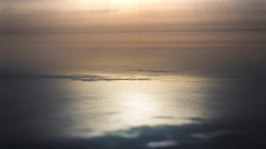 Water reflects sunlight as the sun breaks through the thick clouds