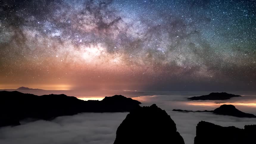 Time lapse of a starry sky moving over a sea of clouds in the mountains