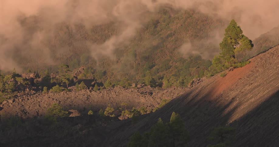 Low clouds passing over mountainous hills with vegetation