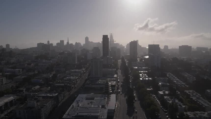 The sun reflects off building tops in a big city during the day