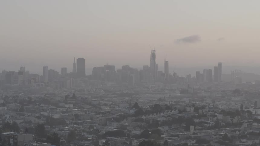 A view of a large city that is smoky or foggy looking