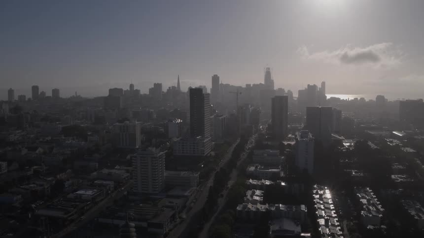 Moving above a large city on a foggy day