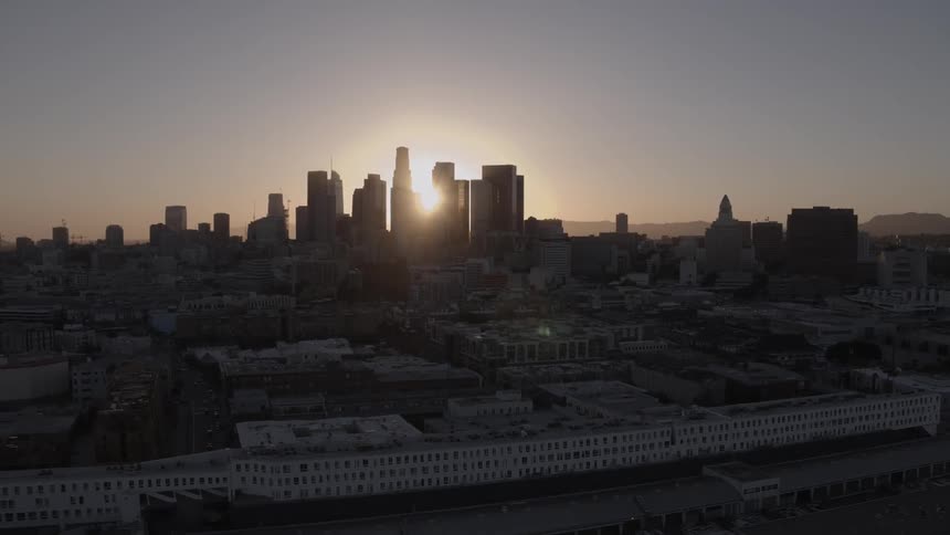 Skyline of a city as the sun is setting behind it