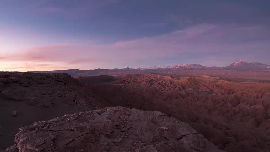Dusty canyon under a blue and pink sunset into darkness