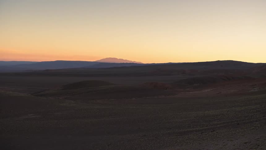 The sun rises and sets in the horizon of the desert