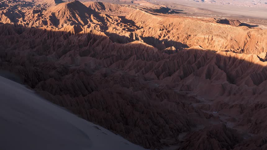 Time lapse of a large shadow rolling over a sharp rugged mountainous landscape