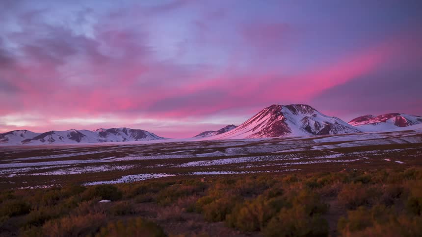 A mountain range landscape cycling from day to night