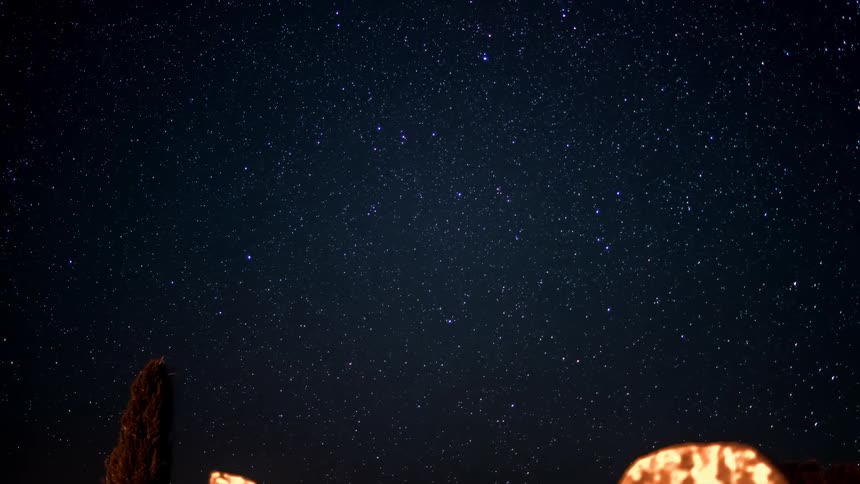 Time lapse of graves on a cemetery under a starry night