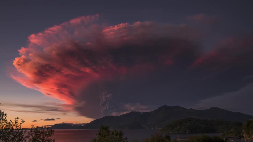 Storm above seaside mountains with reddish sky