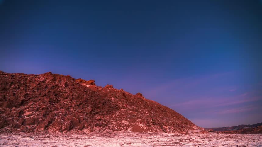 Time lapse of a starry night over the mountains transitioning into sunrise