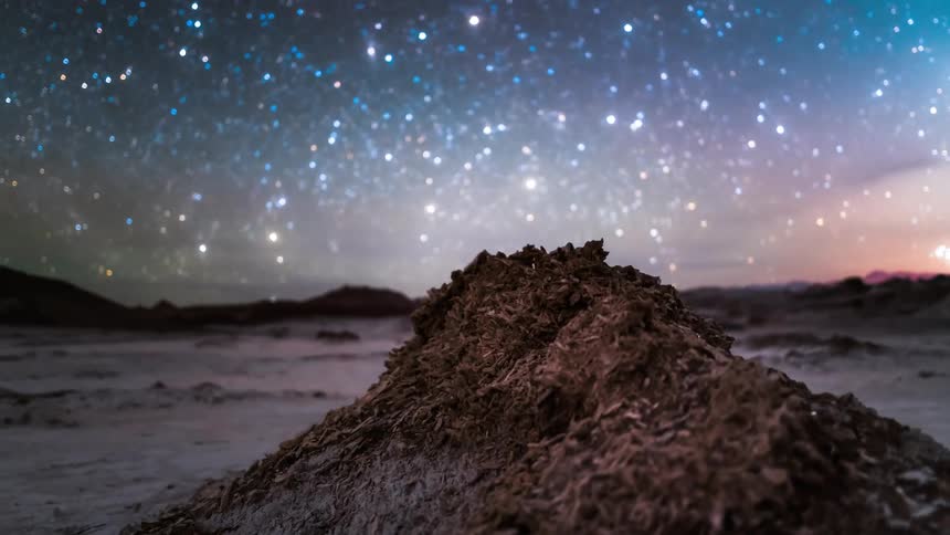 Landscape of a starry night sky with the milky way above the snowy mountains as the day dawns
