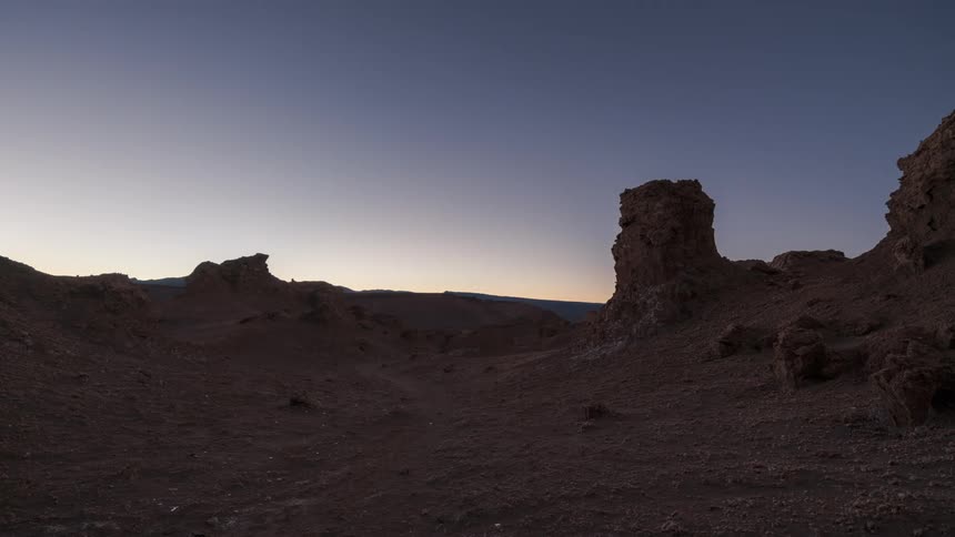Desert landscape with the sun low on the horizon at dusk