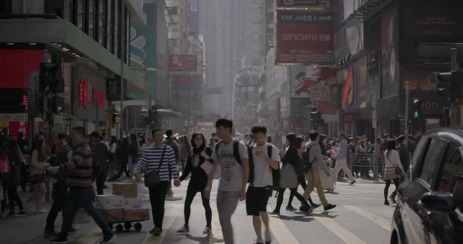 Many people walking on a very busy big city street