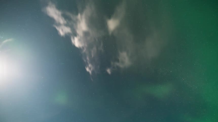 Sky with the sun appearing and a mix of stars and aurora borealis