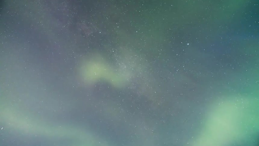 Night sky lit by auroras in shades of green and blue and stars