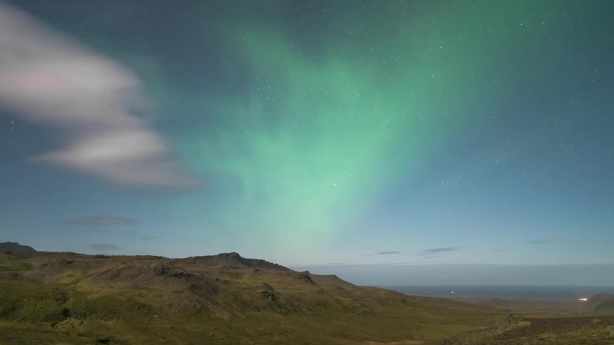 Sky with greenish aurora borealis above mountains