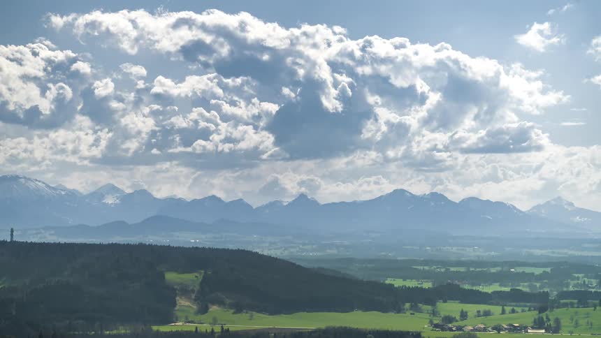 Natural scenery of mountains and green fields with partially cloudy skies