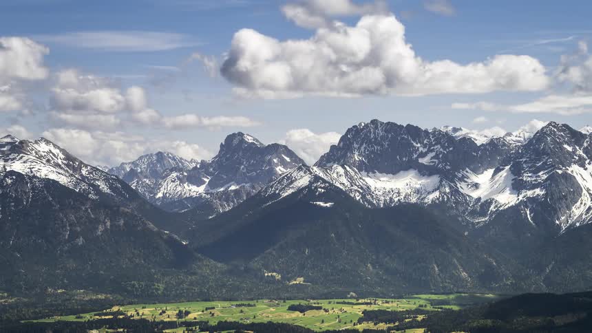 Time lapse of clouds rolling over a valley in the mountains