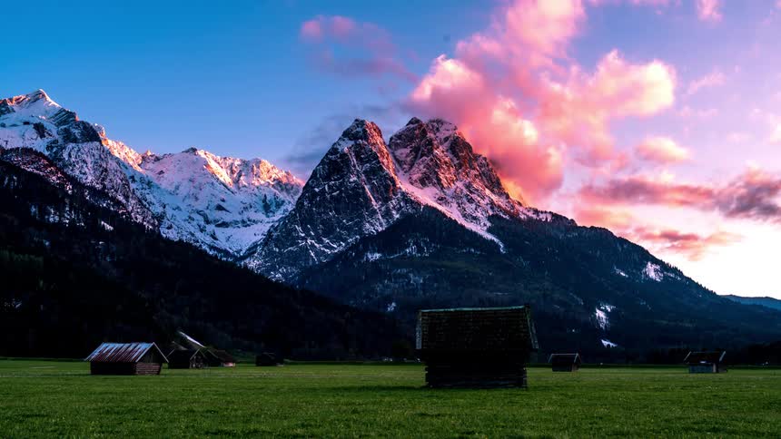 Timelapse of sunset over a rural farm near the mountains