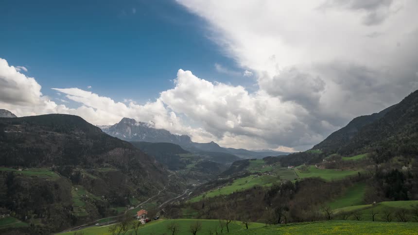 Aerial panorama of green mountains with partly cloudy sky