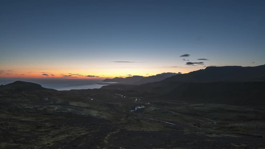 A time lapse of an open landscape shows the transition from night to day