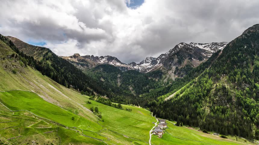 Time lapse of clouds rolling over a sweeping landscape of a mountainous region