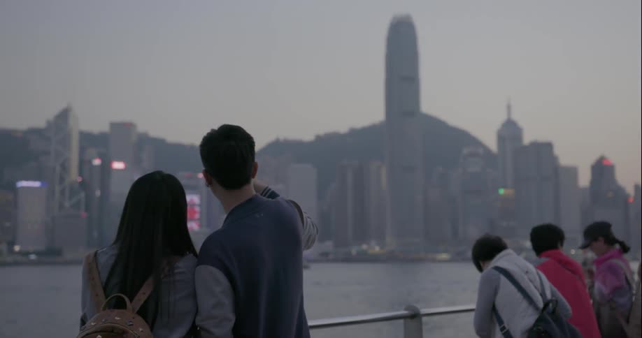 People photographing and observing large city skyline from across a bay