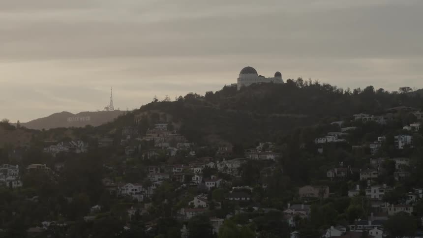A hill with houses scattered around it and a dome like structure at the top