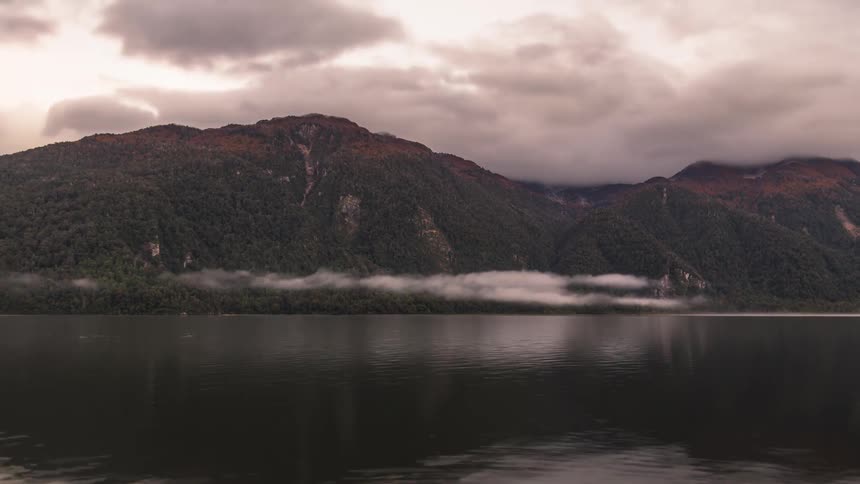 Clouds skim the mountains as the sun rises and then sets again