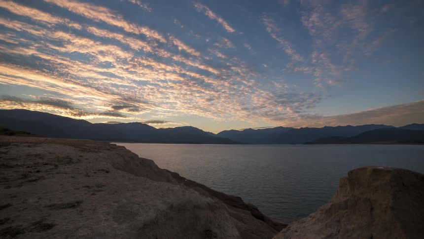Rocky mountains surrounding a lake with a dawning day