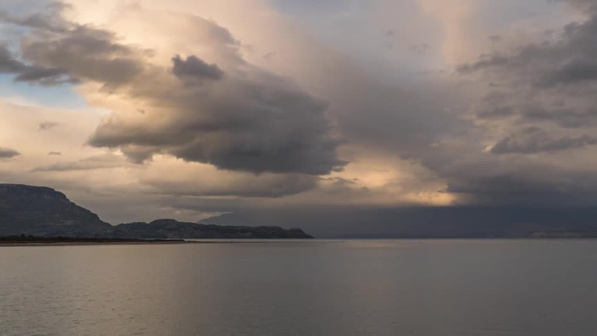 Storm clouds rolling over a large body of water and islands